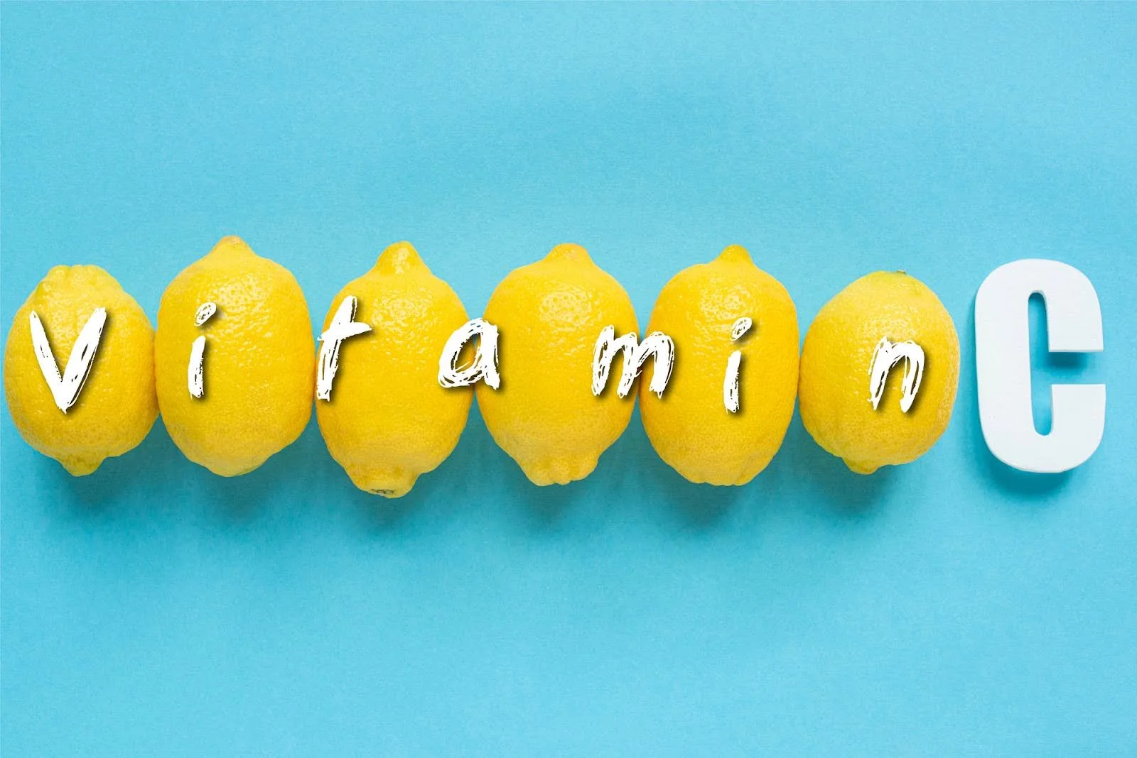 Row of lemons spelling out the word Vitamin C on a light blue background