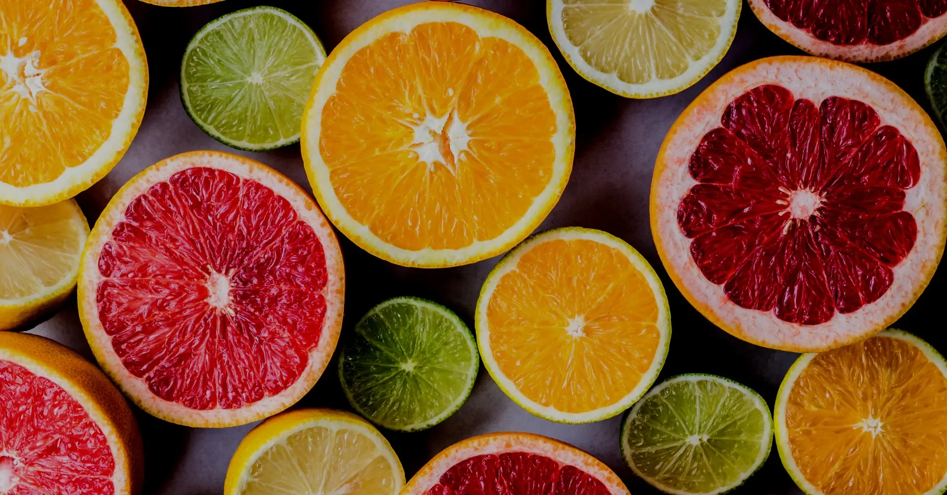 Sliced citrus fruits — oranges, grapefruits, limes and lemons — arranged flat lay