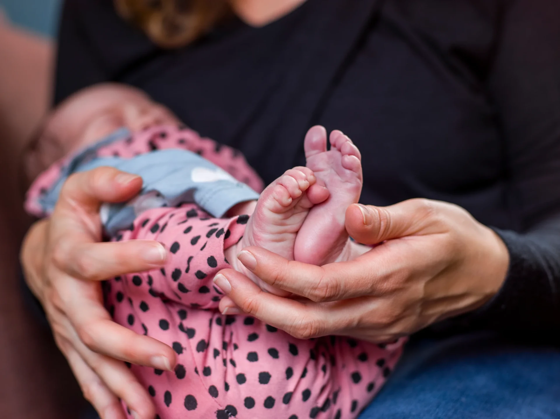 Gentle chiropractor cradling a newborn baby during a calm infant chiropractic visit